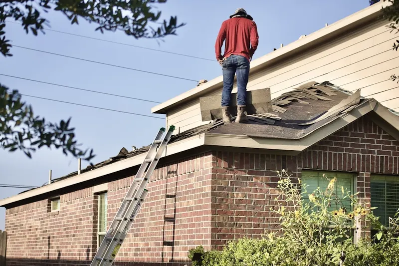 Professional roofer working on a residential roof in Cardwell Colony